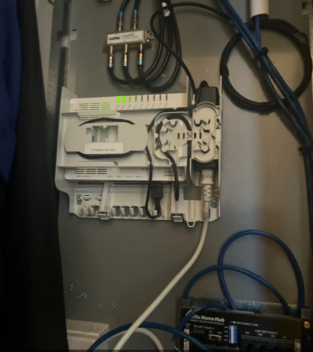 Working NBN equipment and cabling arranged inside a service cabinet